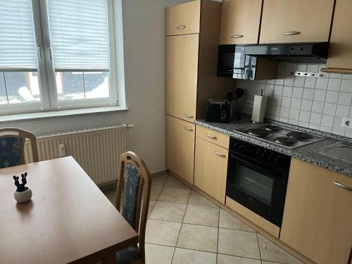 a kitchen with a table and a stove top oven at Bergblick 2 in Masserberg