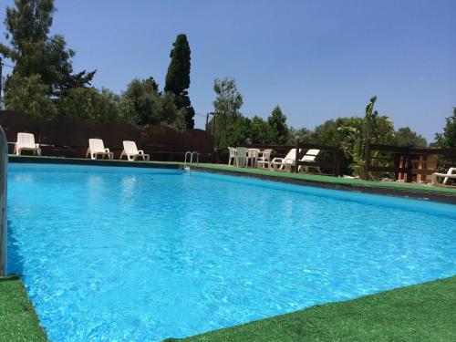 a large blue swimming pool with chairs and tables at Camping Valle dei Templi in San Leone