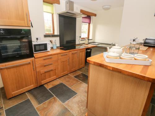 a kitchen with wooden cabinets and a counter top at Cranny in Narberth