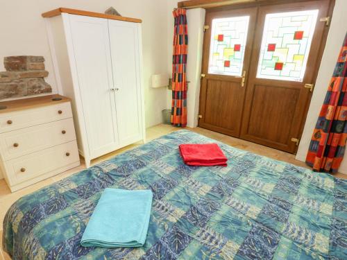 a bedroom with a bed with two towels on it at Cranny in Narberth