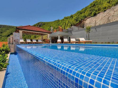 einen Pool mit Stühlen und ein Haus in der Unterkunft Villa Finca Lazeta in Studenci