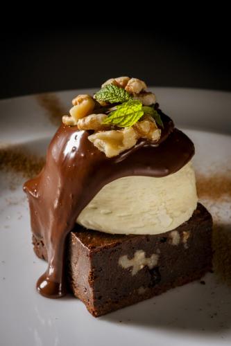 a dessert with chocolate and nuts on a white plate at Hotel Comendador in Carranque