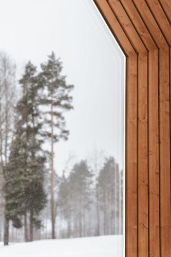 a window of a building with trees in the snow at Sniegi design cabin with sauna in Madona