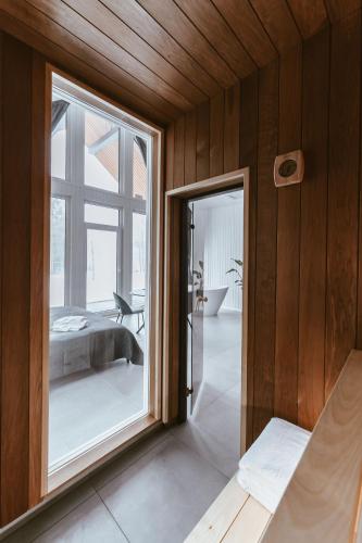 a bedroom with a large glass window and a bed at Sniegi design cabin with sauna in Madona