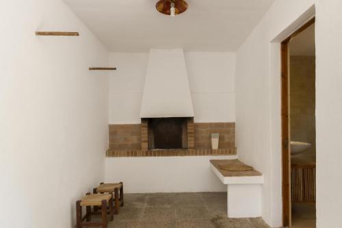 ポリェンサにあるVilla Creusの暖炉と椅子が備わる白い部屋