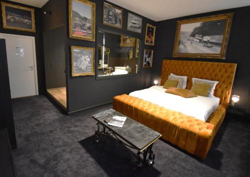 een slaapkamer met een bed, een bank en een spiegel bij Luxury Spa Hotel - Automobile in Spa