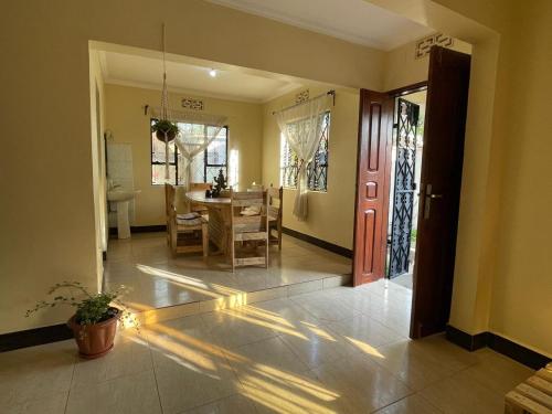 a living room with a table and a dining room at Wonders Hostel in Arusha