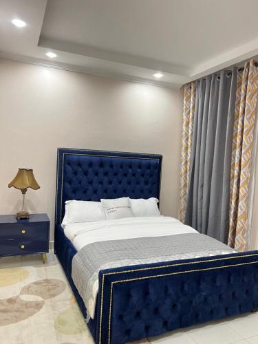 a blue bed in a bedroom with a blue headboard at Regency Stays in Eldoret