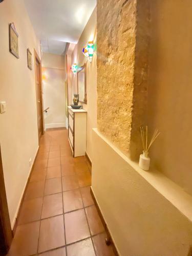 a hallway with a tile floor and a wall with a plant at Balcones con Encanto - vistas al conjunto monumental Patrimonio de la Humanidad in Úbeda