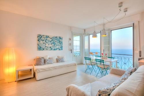 una sala de estar con un sofá y una mesa en La Casa al Sole - beautiful sea view - Happy Rentals, en Cervo