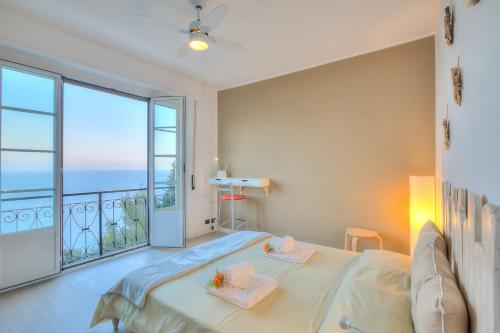 ein Schlafzimmer mit einem Bett und einem großen Fenster in der Unterkunft La Casa Al Sole sea view 400mt from sea - Happy Rentals in Cervo