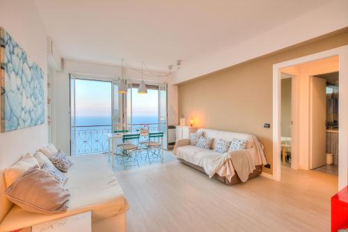 una sala de estar con un sofá y una mesa en La Casa al Sole - beautiful sea view - Happy Rentals, en Cervo