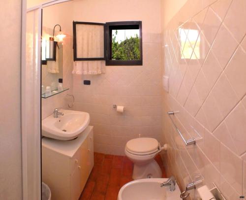a white bathroom with a toilet and a sink at Il Bettarello in Roccastrada