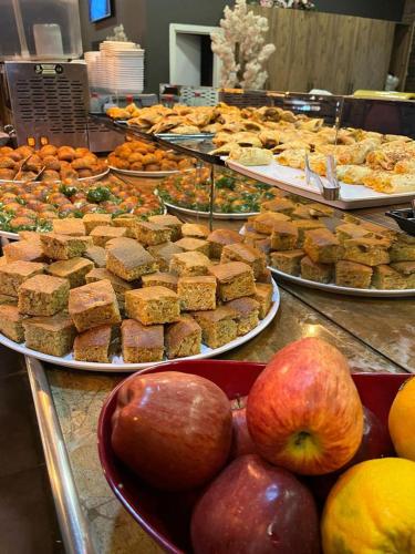 エルズルムにあるGrand Catalkaya Hotelのリンゴやデザートが並んだビュッフェ