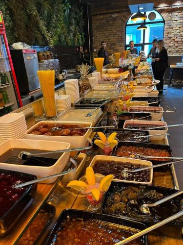 エルズルムにあるGrand Catalkaya Hotelのテーブルの上にたくさんの食べ物のトレーが並んだビュッフェ