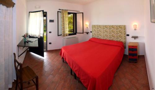 a bedroom with a red bed in a room at Il Bettarello in Roccastrada