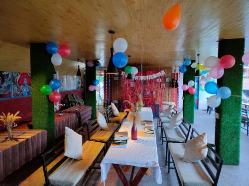 una habitación con una mesa larga con globos y sillas en Bros Hostel & Yaara Cafe, en Manali