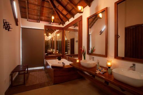 een badkamer met 2 wastafels en 2 spiegels bij StayVista at Cedar @ Strelitzia in Chikmagalur
