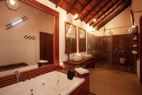 a bathroom with a tub and two sinks and a shower at StayVista at Cedar - Strelitzia 2BHK with Breakfast and Jacuzzi in Chikmagalur