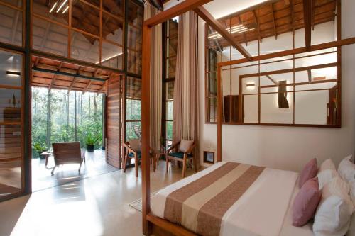 een slaapkamer met een bed en een eetkamer bij StayVista at Cedar @ Strelitzia in Chikmagalur