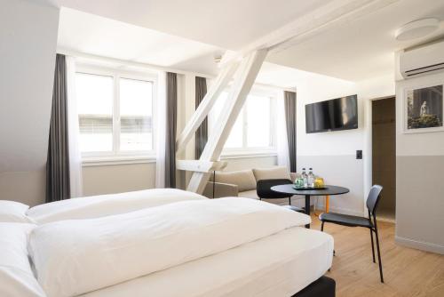 a hotel room with two beds and a table at Fred Hotel Zürich Hauptbahnhof in Zürich