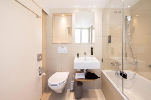 a bathroom with a sink and a toilet and a shower at Fred Hotel Hauptbahnhof in Zurich
