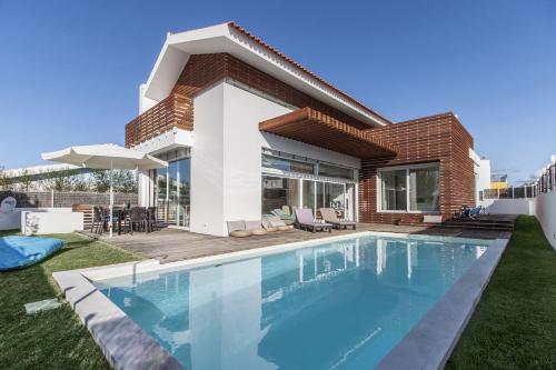 a swimming pool in the backyard of a house at Villa Comporta in Comporta