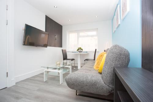 a living room with a couch and a table at Legoland Heathrow Windsor Apartment Hotel in Slough