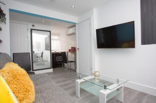 a living room with a couch and a glass table at Legoland Heathrow Windsor Apartment Hotel in Slough