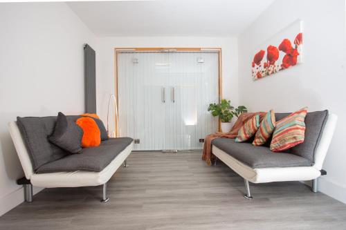a living room with two chairs and a couch at Legoland Heathrow Windsor Apartment Hotel in Slough