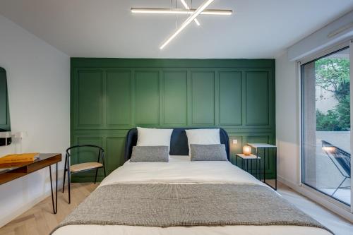 une chambre avec une tête de lit verte et un lit dans l'établissement La Suite - Affaire & Détente à Toulouse, à Toulouse
