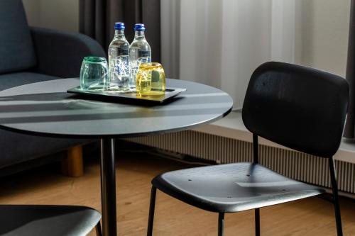 a table with a black chair and bottles on it at Fred Hotel Zürich Hauptbahnhof in Zürich