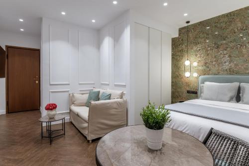 Phaedrus Living Luxury Studio Kolonaki Tsakalof في أثينا: غرفة نوم بسرير واريكة وطاولة