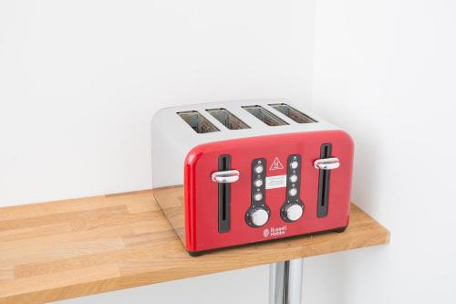 a red and white toaster sitting on a shelf at Legoland Heathrow Windsor Apartment Hotel in Slough