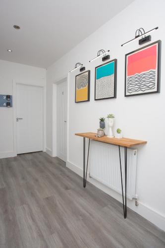 a room with a table and some pictures on the wall at Legoland Heathrow Windsor Apartment Hotel in Slough