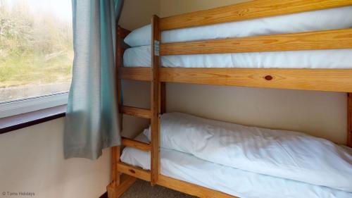 twee stapelbedden in een kamer met een raam bij D56 Beachcomber, Riviere Towans in Hayle