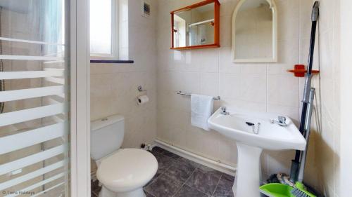 een badkamer met een wit toilet en een wastafel bij D56 Beachcomber, Riviere Towans in Hayle