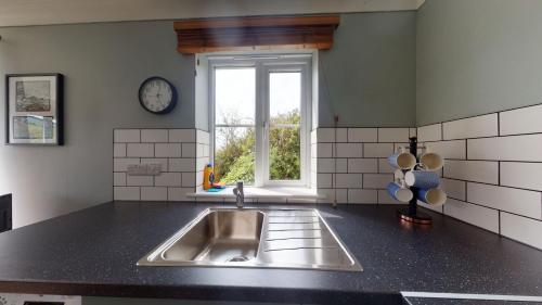 a kitchen with a sink and a window at D59 Estuary View, Riviere Towans in Hayle