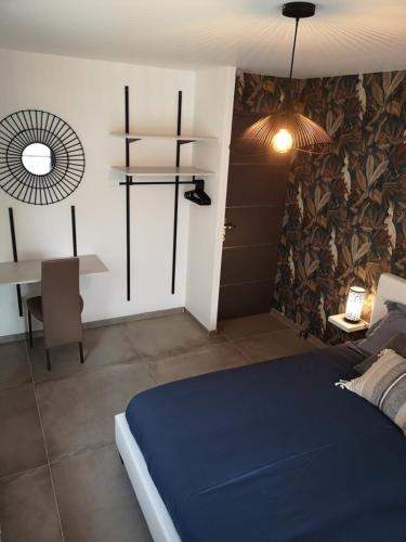 - une chambre avec un lit bleu et une table dans l'établissement Gîte la Winery, à Romery