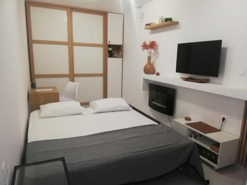 a bedroom with a bed and a flat screen tv at BRIO luxurious urban stay in Heraklio,WiFi,ΑC in Heraklio Town
