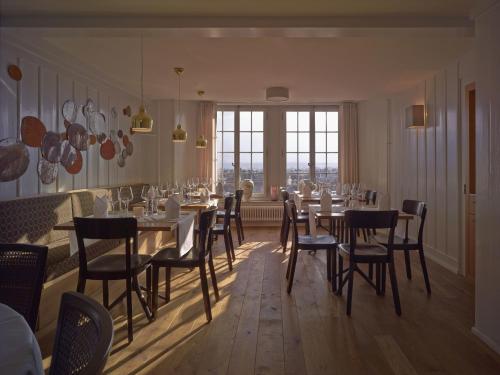 uma sala de jantar com mesas e cadeiras e uma janela em Boutique Hotel Schlossberg em Thun