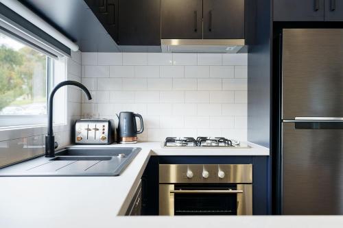 a kitchen with a sink and a stove top oven at Castlemaine Gardens Luxury Accessible Villa in Castlemaine
