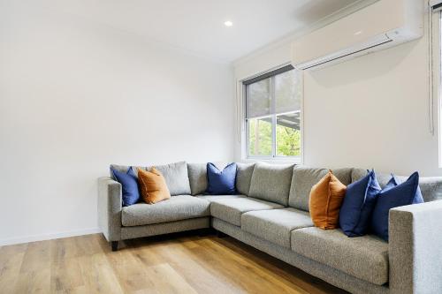 a living room with a couch and a window at Castlemaine Gardens Luxury Accessible Villa in Castlemaine