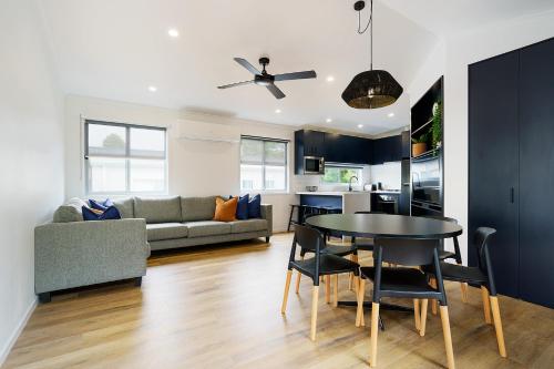 a kitchen and living room with a table and a couch at Castlemaine Gardens Luxury Accessible Villa in Castlemaine