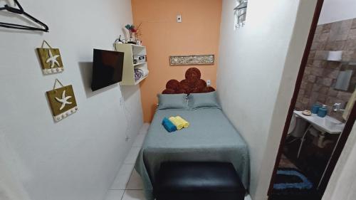 mały pokój z łóżkiem i krzesłem w obiekcie Casinha guagiru w mieście Trairi