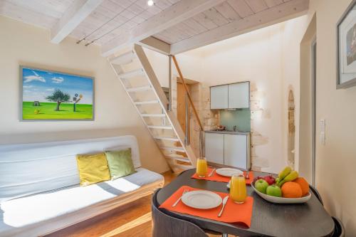 Apartamento pequeño con escalera y mesa con fruta. en Boutique Hotel Fortino, en La Canea