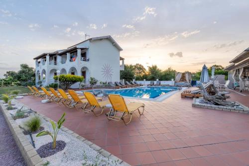 uma villa com uma piscina e espreguiçadeiras em Villa Del Sol Corfu em Sidari