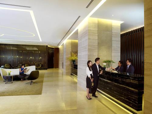 a group of people standing in a lobby at One Farrer Hotel in Singapore