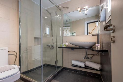 a bathroom with a glass shower and a sink at Boutique Hotel Fortino in Chania