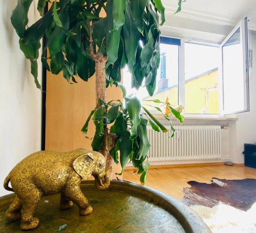 a statue of an elephant standing next to a tree at Helle, grosse, zentrale Wohnung mit Balkon in Munich